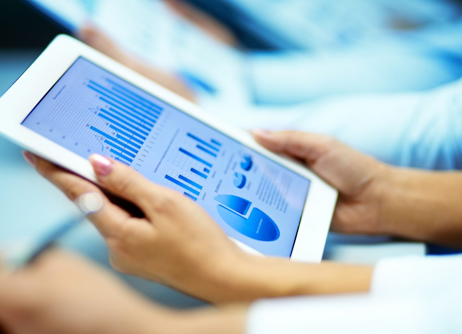 Businesswoman hands with touchpad while learning situation on the market